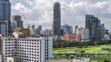Bangkok, Thailand - 12 August 2022 - Time lapse view of Bangkok cityscape with high-rise buildings and BTS skytrains with moving clouds