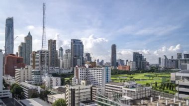 Bangkok, Thailand - 12 August 2022 - Time lapse view of Bangkok cityscape with high-rise buildings and BTS skytrains with moving clouds