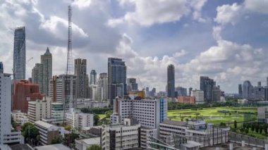 Bangkok, Thailand - 12 August 2022 - Time lapse view of Bangkok cityscape with high-rise buildings and BTS skytrains with moving clouds