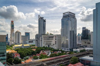 Bangkok, Thailand - 13 August 2022 - Aerial view of Bangkok cityscape in the morning showing high-rises with a golf course and cloudy blue sky