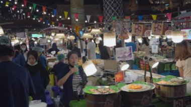 Bangkok, Thailand - 10 August 2022 - Shoppers and vendors buy and sell food at the food market in Icon Siam food hall in Bangkok, Thailand
