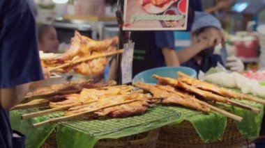 Bangkok, Thailand - 10 August 2022 - Food vendor setting up his Thai style barbeque chicken on stick at Icon Siam food hall