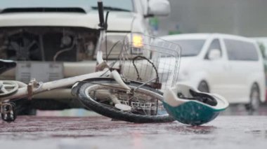 Bicycle helmet spinning and falling down bicycle on the road after traffic accident on a raining day