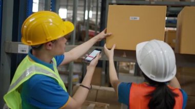 Male and female warehouse staff working together to check the inventory by scanning barcode on the product boxes