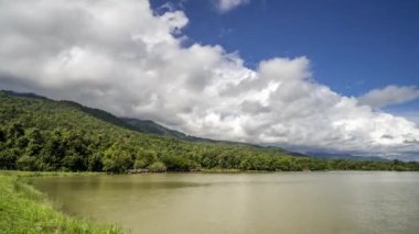 Tayland, Chiang Mai 'deki Huay Thung Tao parkındaki dağların ve gölün üzerinden geçen beyaz bulutların zaman akışı.