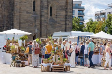 Magdeburg, pottery market - August 6, 2022: People buy useful pottery, funny pottery, decorations and art objects for home comfort on the old market square