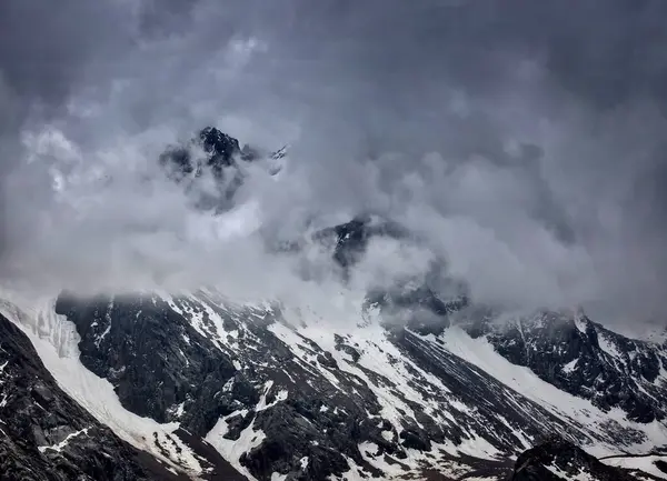 Kuzey Tien Shan dağlarında kayalar ve karla kaplı bir manzara..