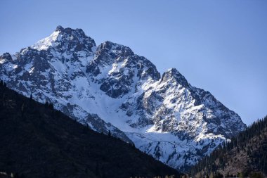 Almaty şehrindeki karlı dağ zirveleri.