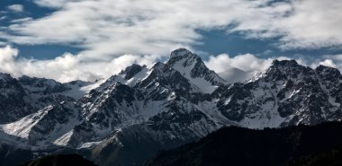 Almaty şehrindeki dağların üzerinden bulutlarla kaplı manzara.