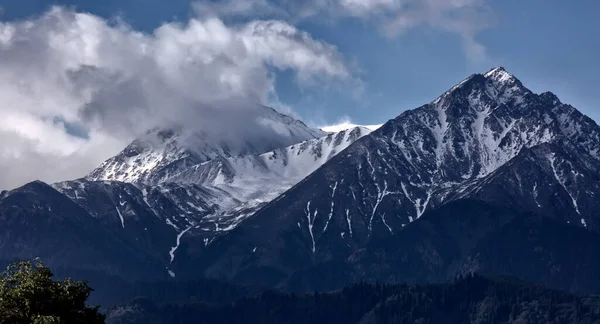 Almaty şehrindeki dağların üzerinden bulutlarla kaplı manzara.