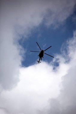 Helikopter bulutların arka planında uçar..