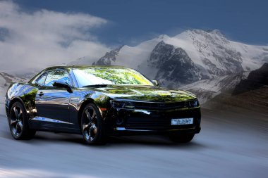 Hareket halindeki Chevrolet siyah araba, doğal arka plan bulanıklığı.