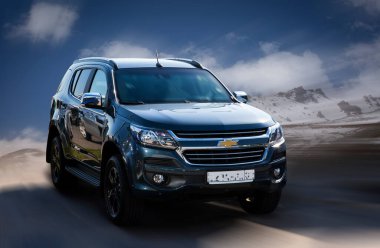 Hareket halindeki Chevrolet siyah araba, doğal arka plan bulanıklığı.