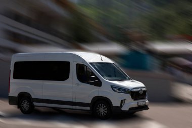 Hareket bulanık arkaplanda kiraz beyazı elektrikli minibüs.