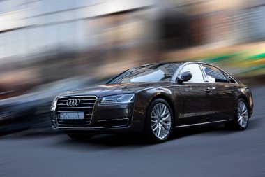 Arkaplanı bulanık olan siyah bir araba.