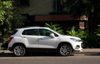 Arka planda bulanık hareket eden beyaz bir araba.