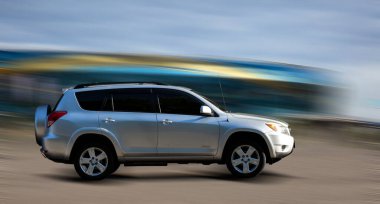 Hareket halindeki araba arka planda bulanık.