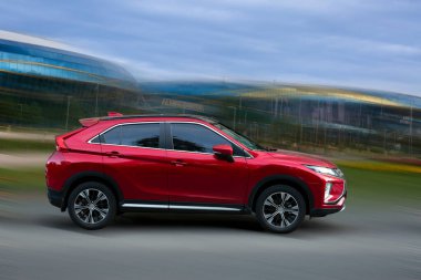 Hareket halindeki kırmızı araba arka planda bulanık.