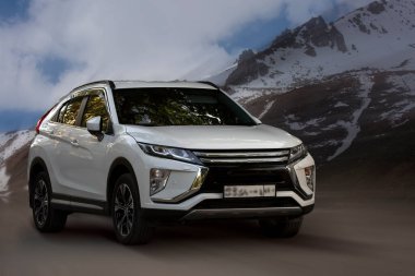 Arka planda bulanık hareket eden beyaz bir araba.