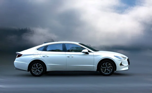 Arka planda bulanık hareket eden beyaz bir araba.