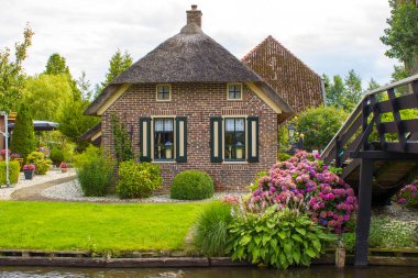 GIETHOORN, NETHERLANDS - evlerin ve bahçelerin tipik Hollanda ilçesi