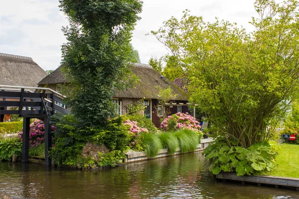 GIETHOORN, NETHERLANDS - evlerin ve bahçelerin tipik Hollanda ilçesi