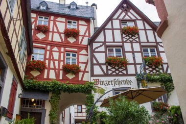 BEILSTEIN, GERMANY - Ekim 03 2019: Moselle nehri kıyısında tarihi bir köy. Eski ahşap evler ve tepelerin tepesinde Metternich Kalesi kalıntıları var.