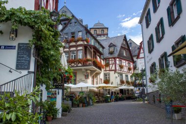BEILSTEIN, GERMANY - SEPTEMBER 03 2022: Moselle nehri kıyısındaki tarihi köy eski ahşap evleri ve tepelerin tepesinde Metternich kalesinin kalıntıları var.