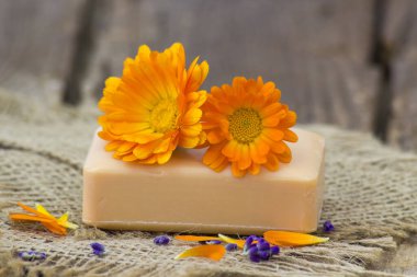 Doğal el yapımı Sabun rustik ahşap zemin üzerine calendula (pot kadife çiçeği) ile