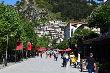 Berat, Arnavutluk - 7 Mayıs 2021. Arka planda eski kasaba manzaralı, Berat 'ın ana yaya caddesi, binlerce pencereli ya da binlerce ışıklandırmalı şehir olarak adlandırılır.