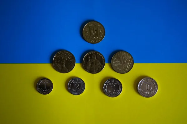 ウクライナの国旗を背景に1 10の宗派でウクライナの硬貨 青と黄色 — ストック写真