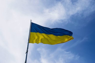 Mavi gökyüzünde dalgalanan Ukrayna bayrağı. Büyük sarı Ukrayna ulusal bayrağı. Rusya Ukrayna 'ya saldırdı