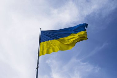 Flag of Ukraine flutters in blue sky. Large yellow blue Ukrainian national state flag. War Russia attacked Ukrain