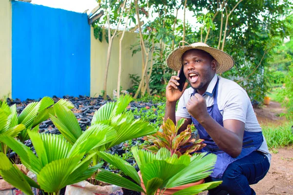 African Male Gardener Florist Horticulturist Wearing Apron Hat Making Phone — Stockfoto