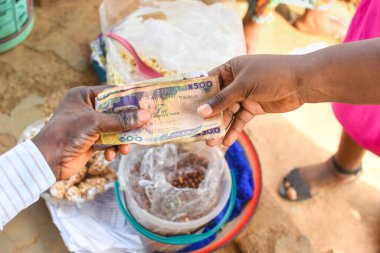 Cash, money or Nigerian currency exchanging hands during a business transaction with edible food in the background