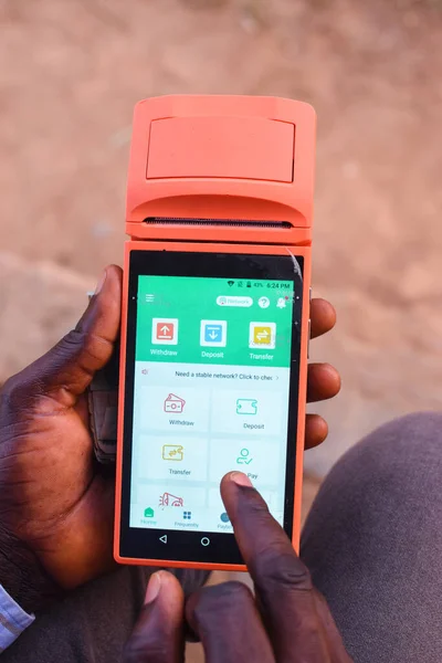 African hands using a point of sales terminal known as POS for business purposes with a finger on the screen on the financial based digital device