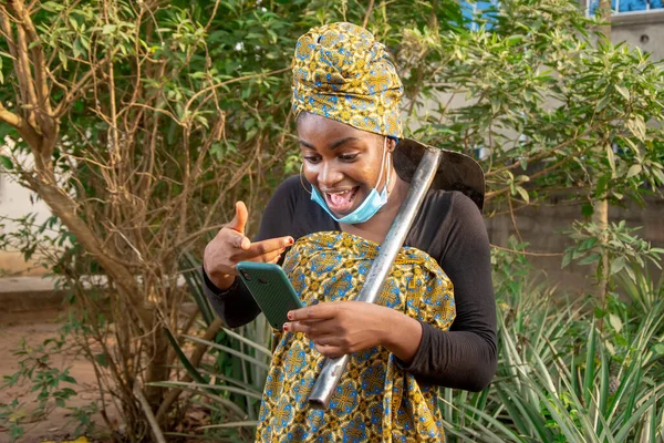 Beautiful African Female Farmer Nose Mask Checking Her Smartphone Hoe — Foto Stock