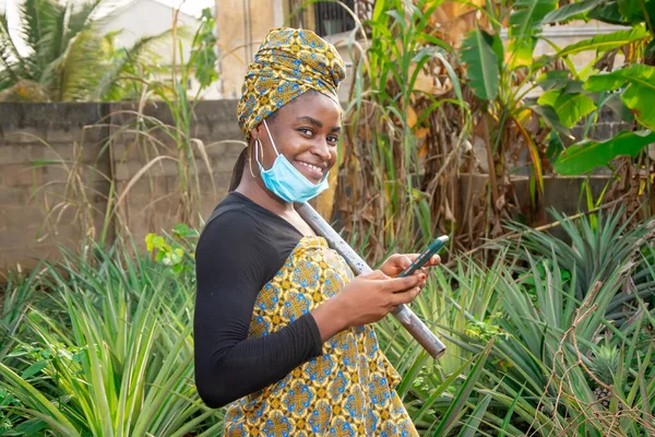 Beautiful African Female Farmer Nose Mask Checking Her Smartphone Hoe — Foto Stock