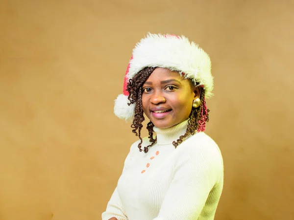 Close up portrait of a cute African lady or woman having a Christmas cap on her head