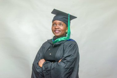 Portrait of a happy African female graduand or graduating students smiling in her black outfit