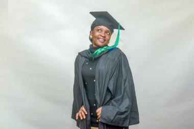 Portrait of a happy African female graduand or graduating students smiling in her black outfit