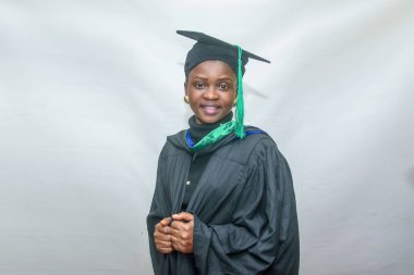 Portrait of a happy African female graduand or graduating students smiling in her black outfit