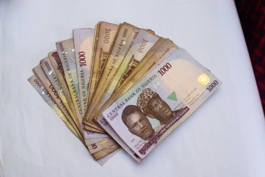 Çok sayıda yayılmış Nijerya malı 1000 naira banknot, para ya da nakit para beyaz bir masaya konur.