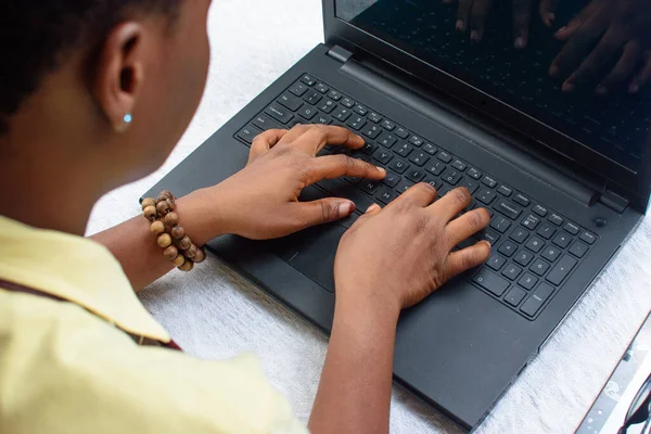 Female African hands with beads using laptop or computer by typing on the keyboard
