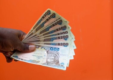 An African hand holding set of spread multiple naira notes, cash or nigerian currency