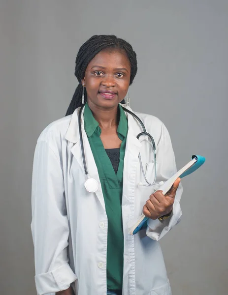 A lady or female medical practitioner from Nigeria with writing pad and stethoscope around her neck representing medical practitioners like doctors, nurses, surgeon, physician,dentist among others