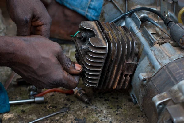 An Engineer working on a small electricity generator in an engineering workshop, undergoing repair and maintenance for better generation of electrical energy for household and business in Nigeria