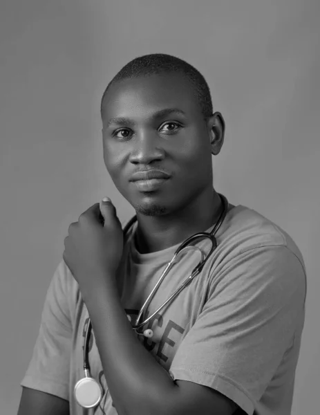 Monochrome picture of an African Nigerian man with stethoscope around his neck representing medical experts or practitioners like doctor, Nurse, Surgeon, physician, dentist, pharmacist among others