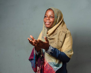 An African Nigerian female muslim lady with Hijab scarf, engaging the process of prayer or ablution which is more noticeable during ramadan and when going to mosque