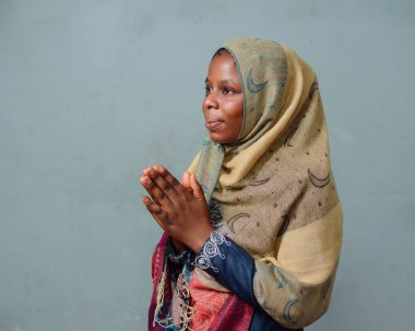 An African Nigerian female muslim lady with Hijab scarf, engaging the process of prayer or ablution which is more noticeable during ramadan and when going to mosque